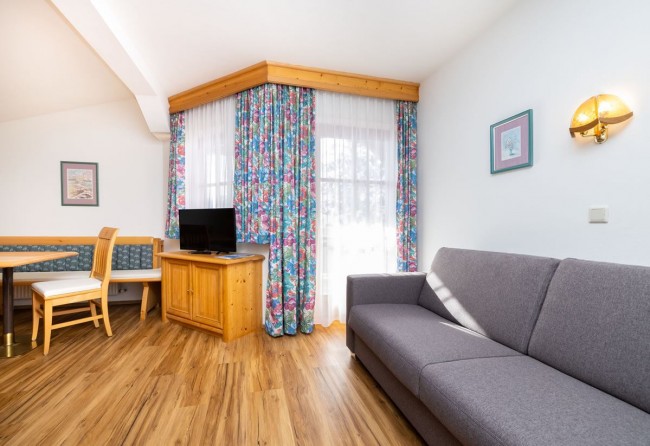 Wohnzimmer mit Couch und Flat-TV