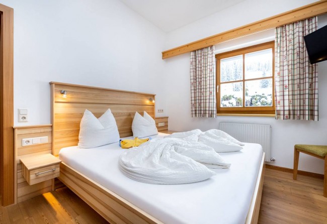 Schlafzimmer mit Doppelbett und Flat-TV